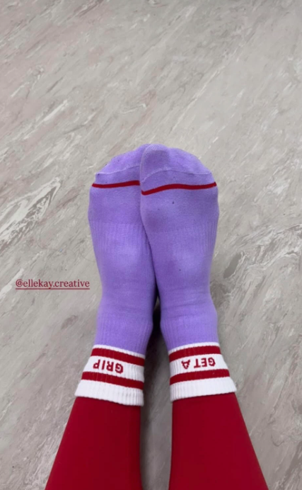 Purple and red socks on a gray floor